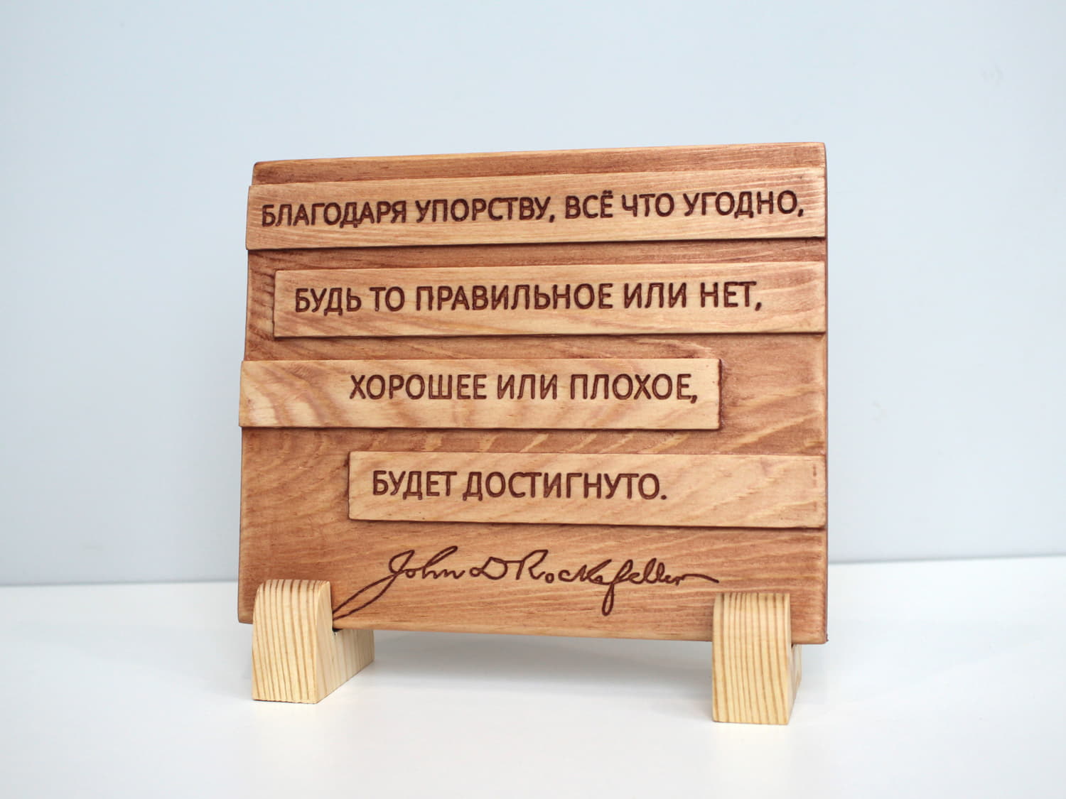 Табличка с цитатой Джона Рокфеллера «Благодаря упорству, все что угодно, будь то правильное или нет, хорошее или плохое, будет достигнуто»