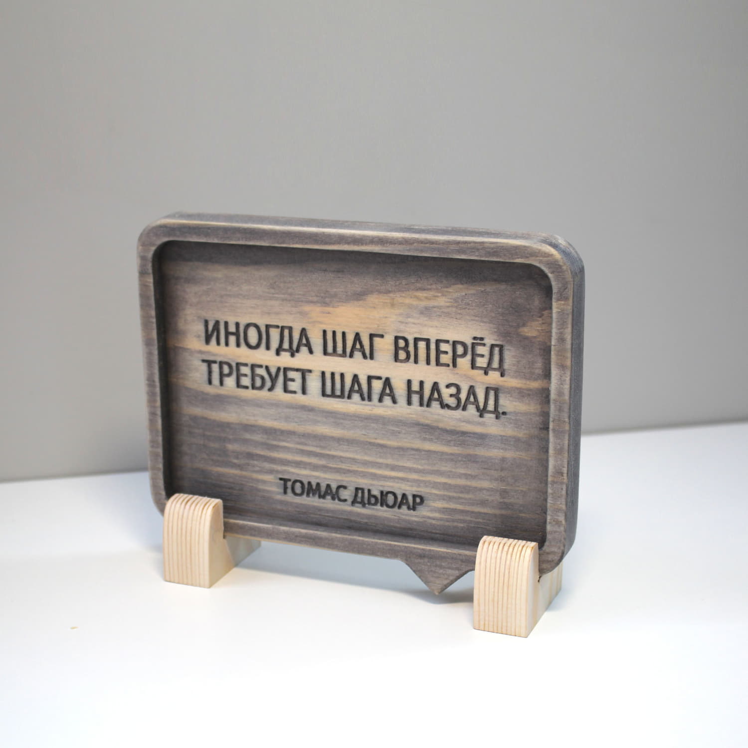 Табличка с цитатой Томаса Дьюара «Иногда шаг вперед требует шага назад»